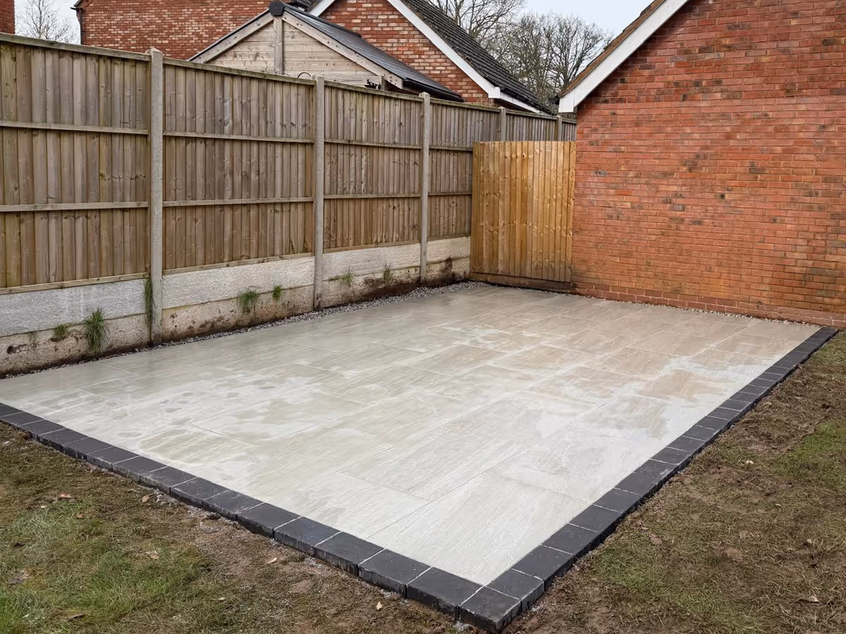 Grey porcelain patio with charcoal pencil edge paving. 