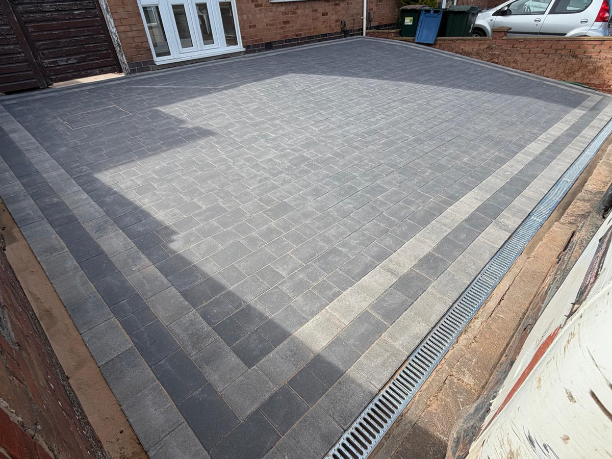 Charcoal Rumbled paving set driveway and an ACO channel drainage system