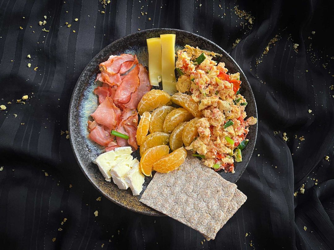 Assiette petitdéjeuner oeufs brouillés, bacon, fromage et clémentine faible en calories