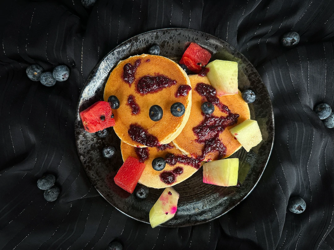 Le pancake de blancs d'oeufs à l'avocat, miel, cannelle et fruits rouges est présenté dans un petit saladier en grès de couleur beige.