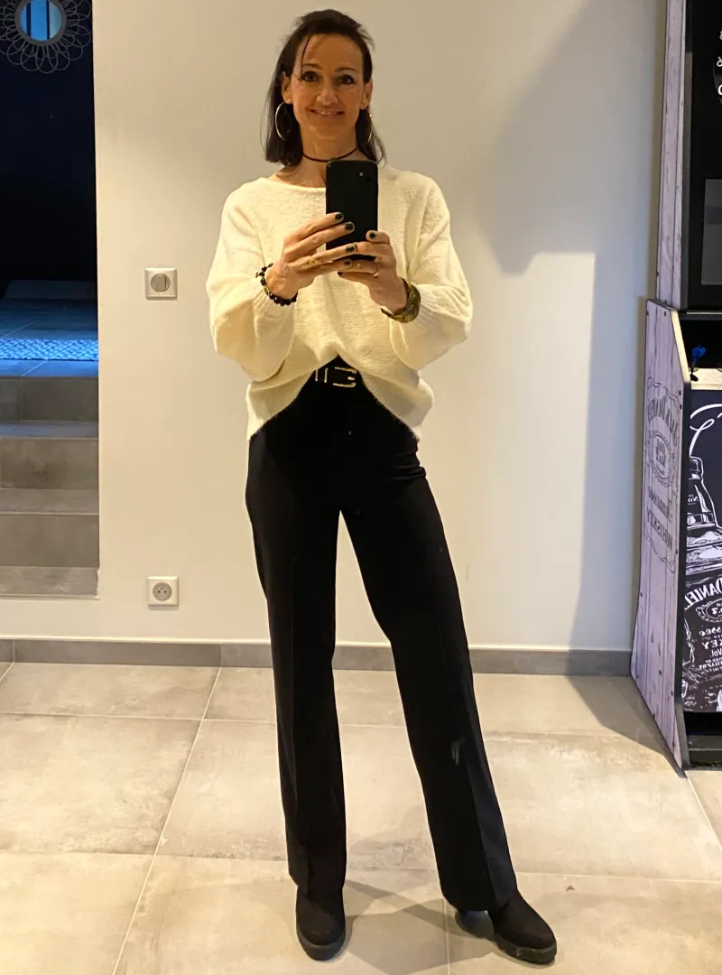 Une femme ayant transformé son corps se prend en photo dans sa tenue préférée.