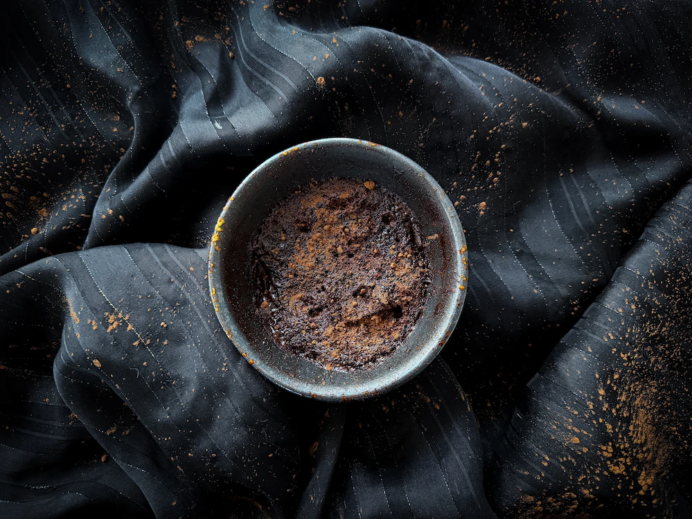 Un mugcake au chocolat est déposé sur un fond noir. 