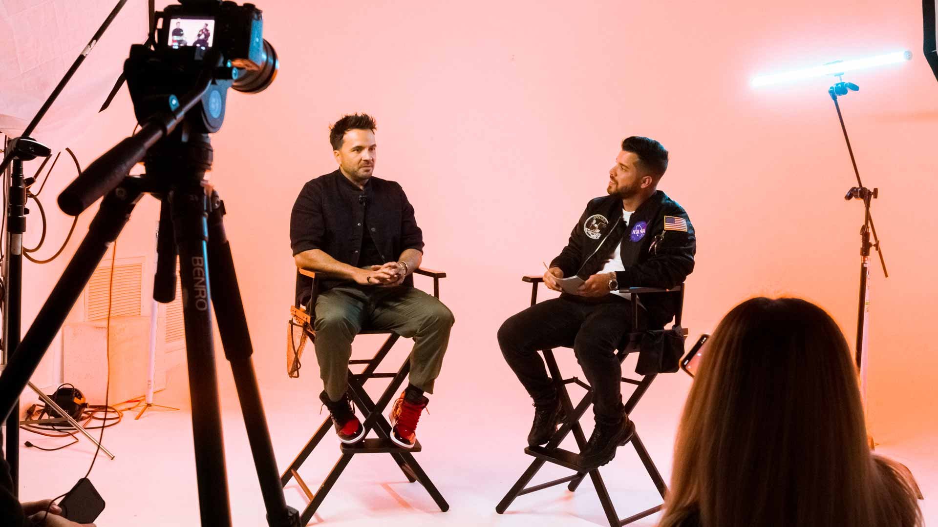 Alex Quin interviewing a guest on the Hustle Inspires Hustle studio set