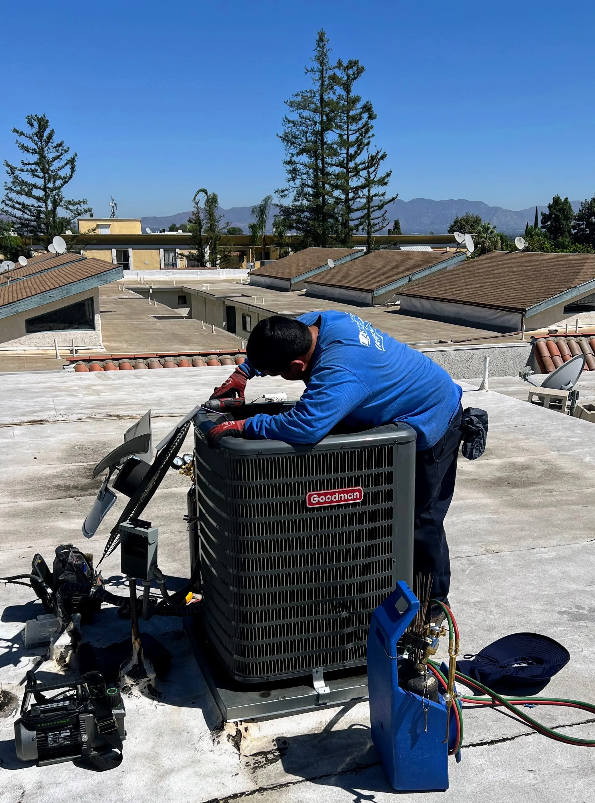 LA Heating and Air Technician repairing AC Unit on roof