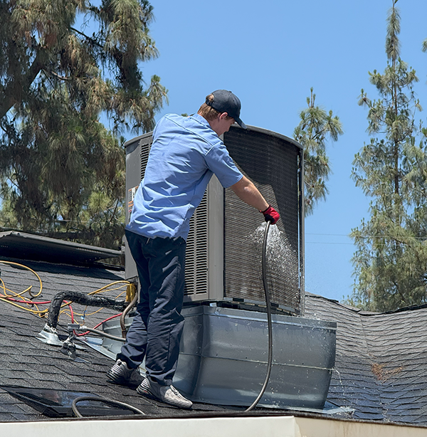 HVAC Technician working on a unit on rooftop