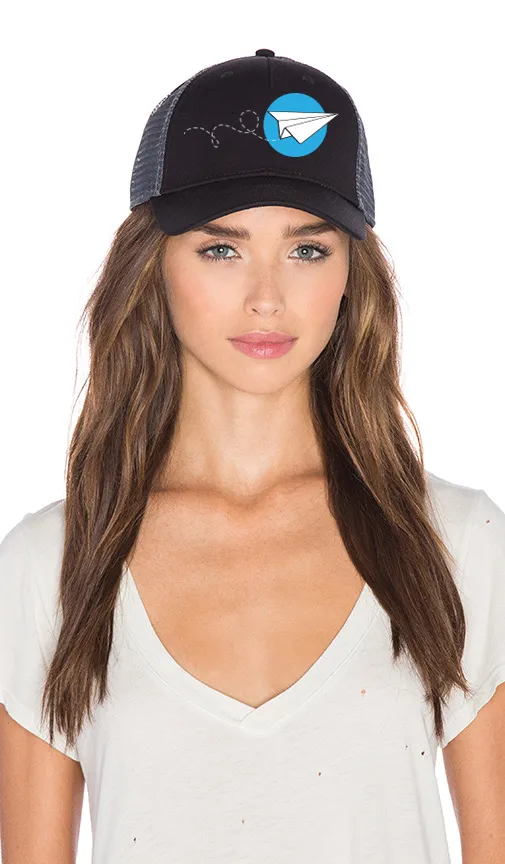 Woman wearing a Giving to Fly cap