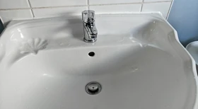 White ceramic basin with a chrome mixer tap and decorative period-style detail