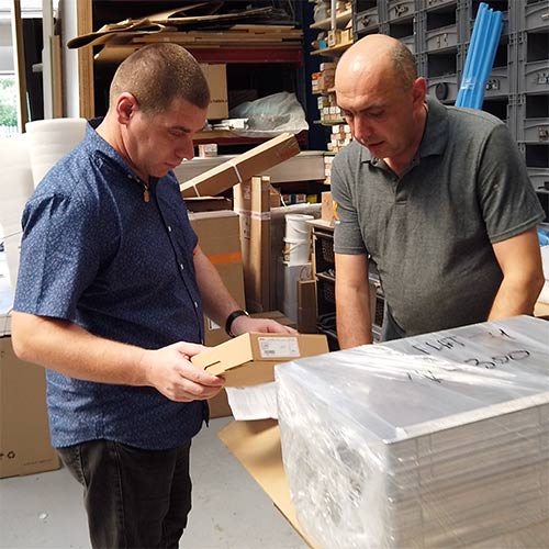 Two men inspecting items in a workshop