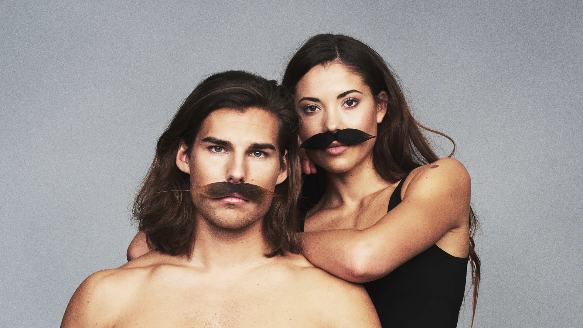 Manlig och kvinnlig modell i stora lösmustascher