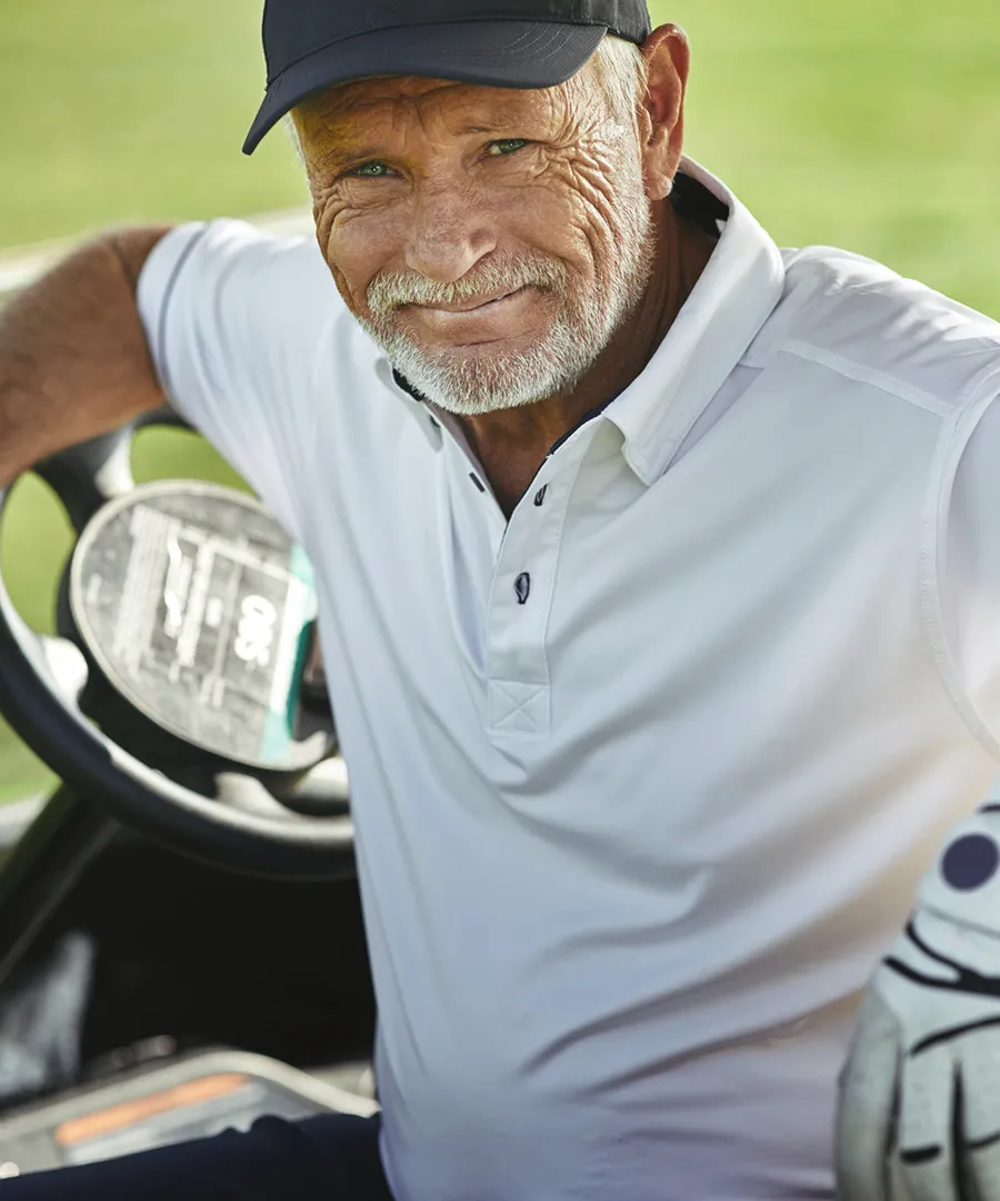 Leende man sitter i en golfbil