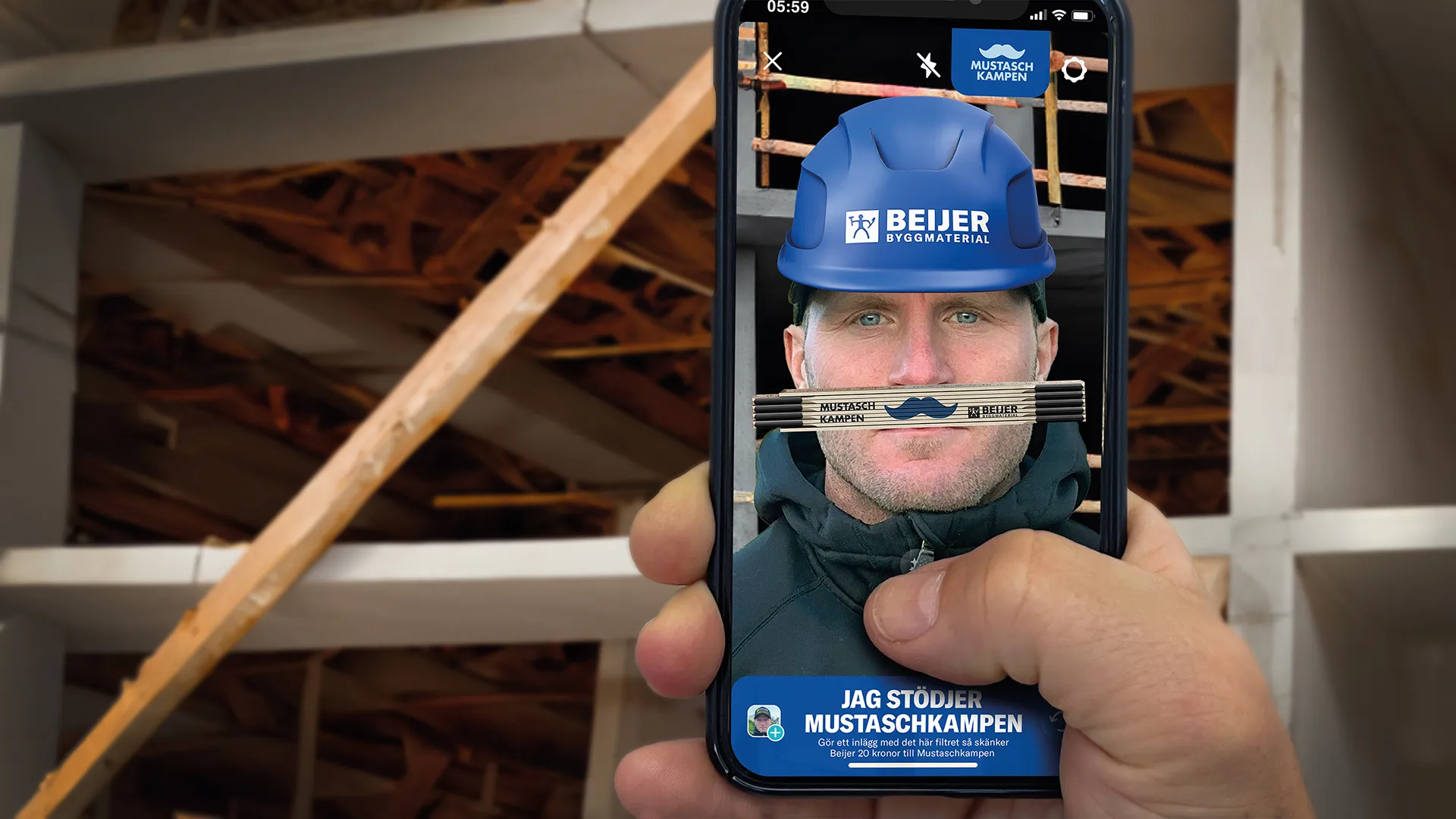 Hand som håller i en telefon, på skärmen visas en man med blå bygghjälm och en tumstock som mustasch