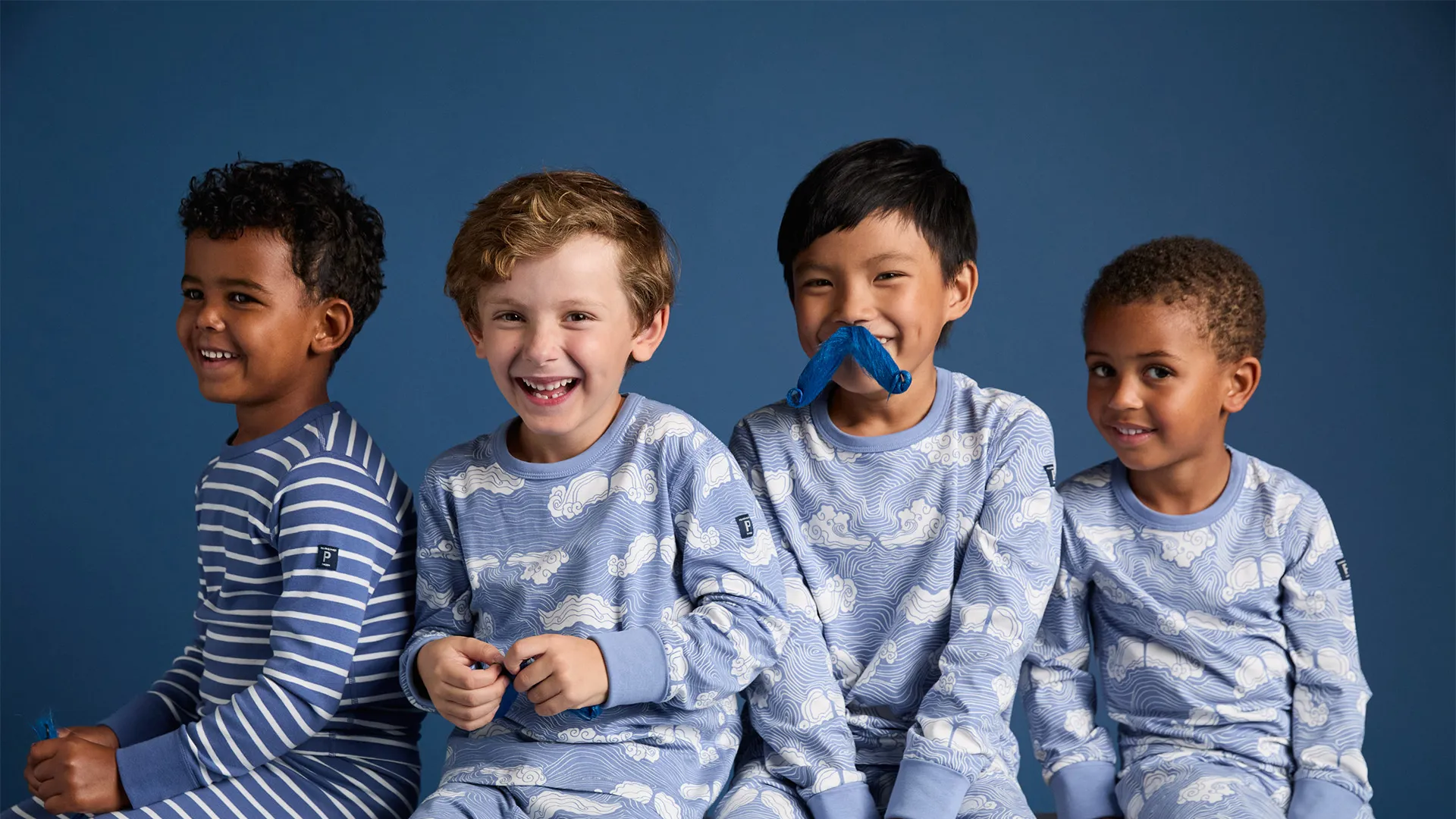 Barn iklädda pyjamas med moninspirerande mustascher