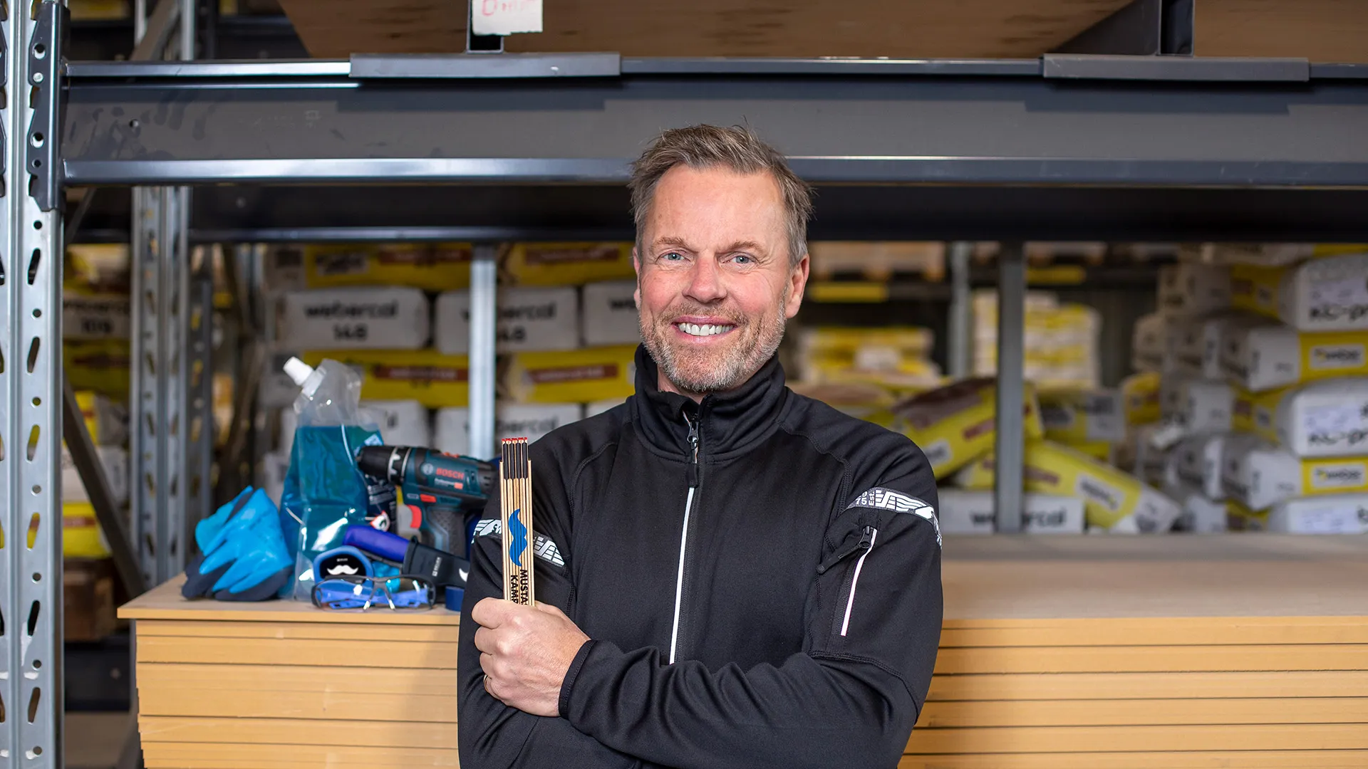 Glad man med en meterstock i ena handen