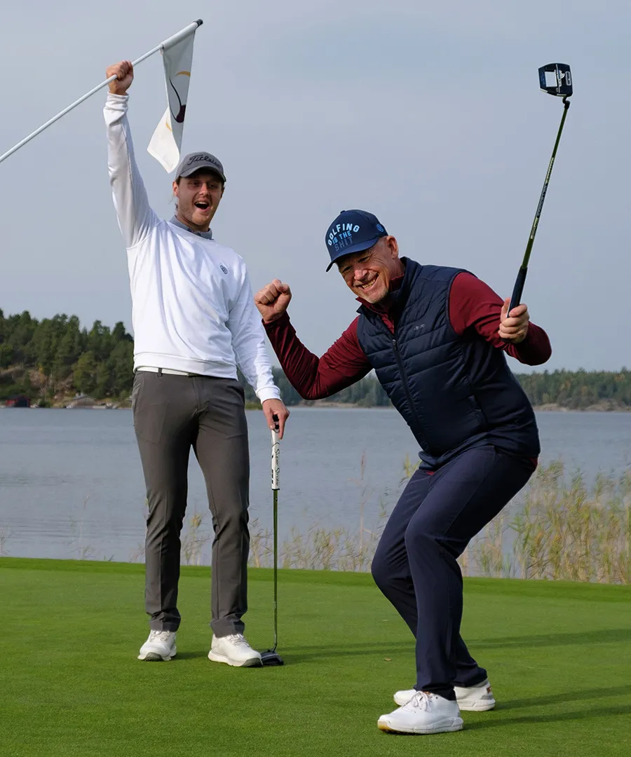 Två glada golfspelare höjer armarna i skyn
