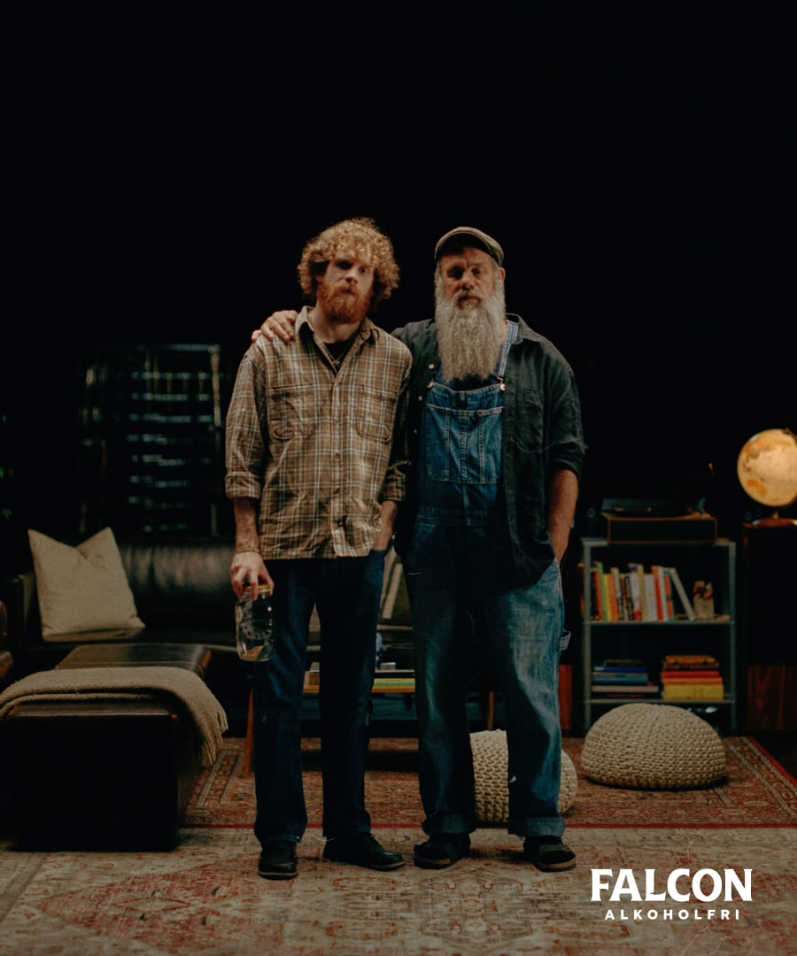 Far och son med allvarlig uppsyn står tillsammans i ett vardagsrum