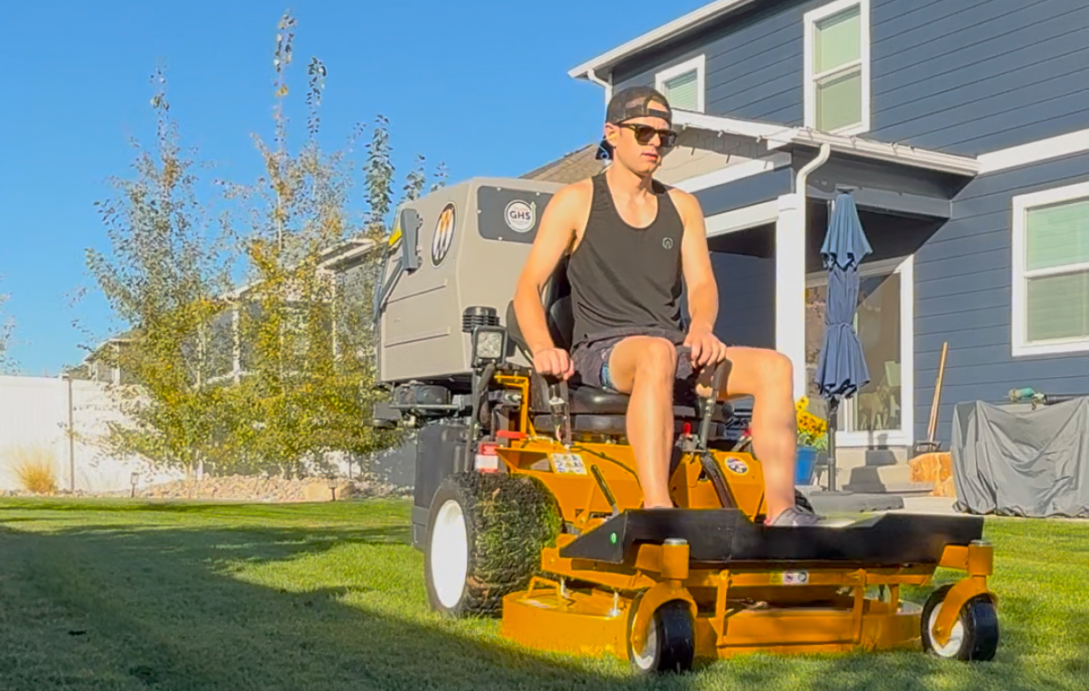 Seth mowing the lawn on his Walker mower
