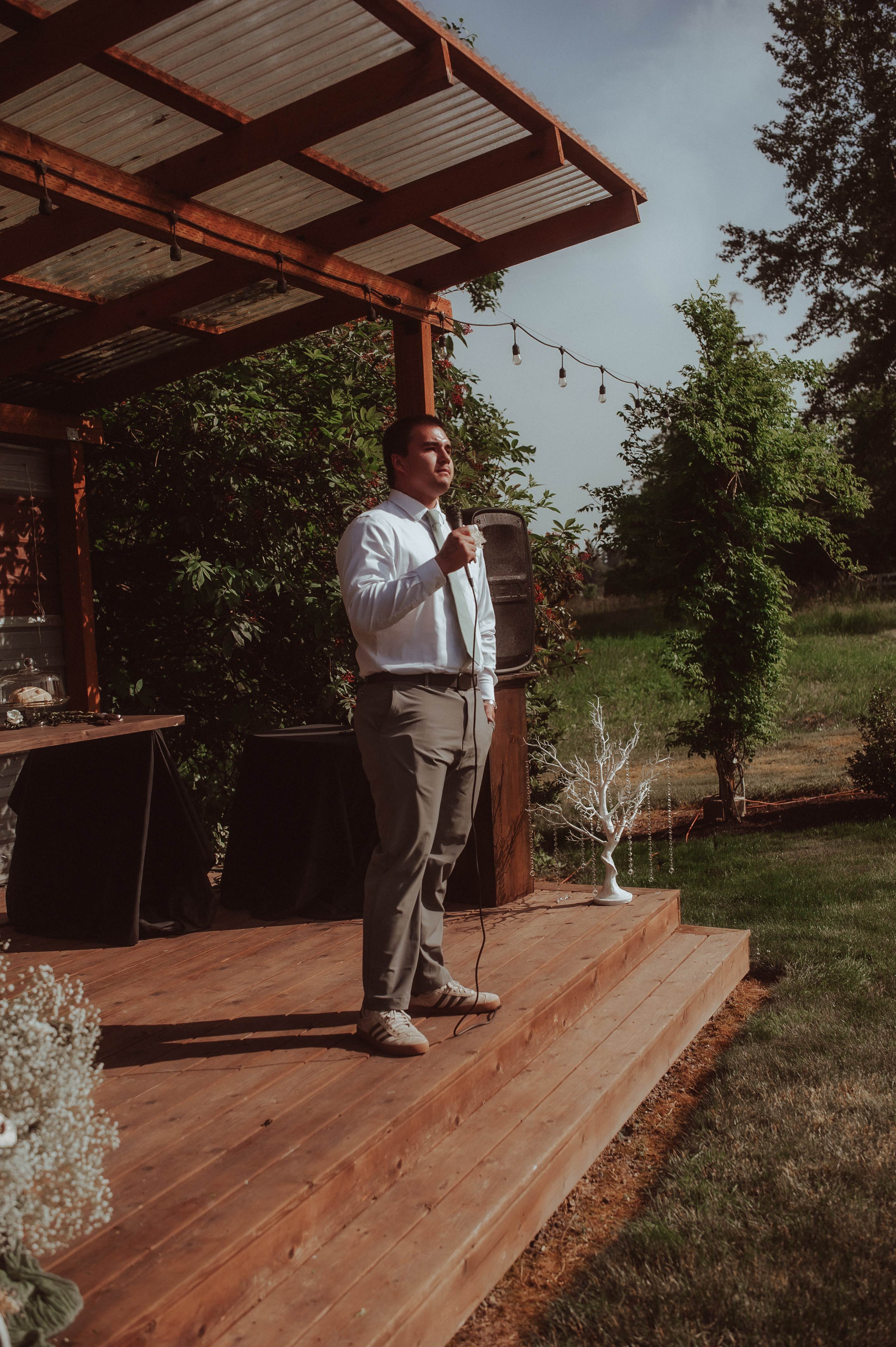 man speaking outdoor stage