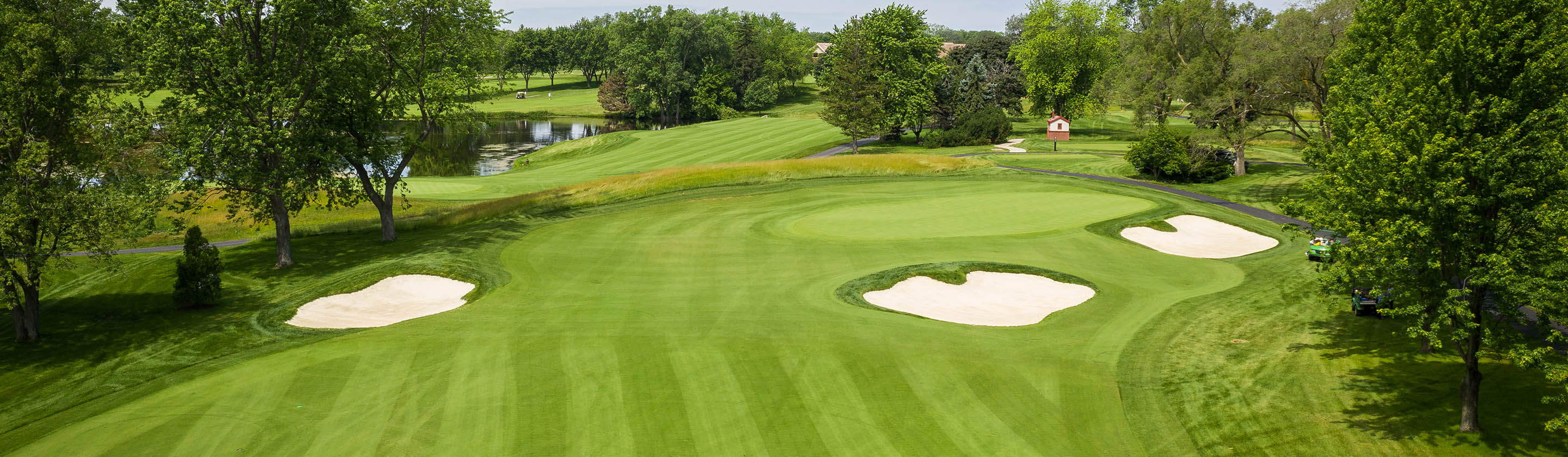 Schaumburg Golf Club green surrounded by sand bunkers and trees.