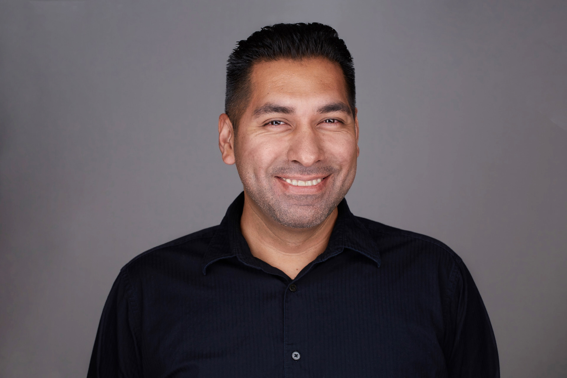 Profile headshot image of Andrew Guillen, wearing a black shirt