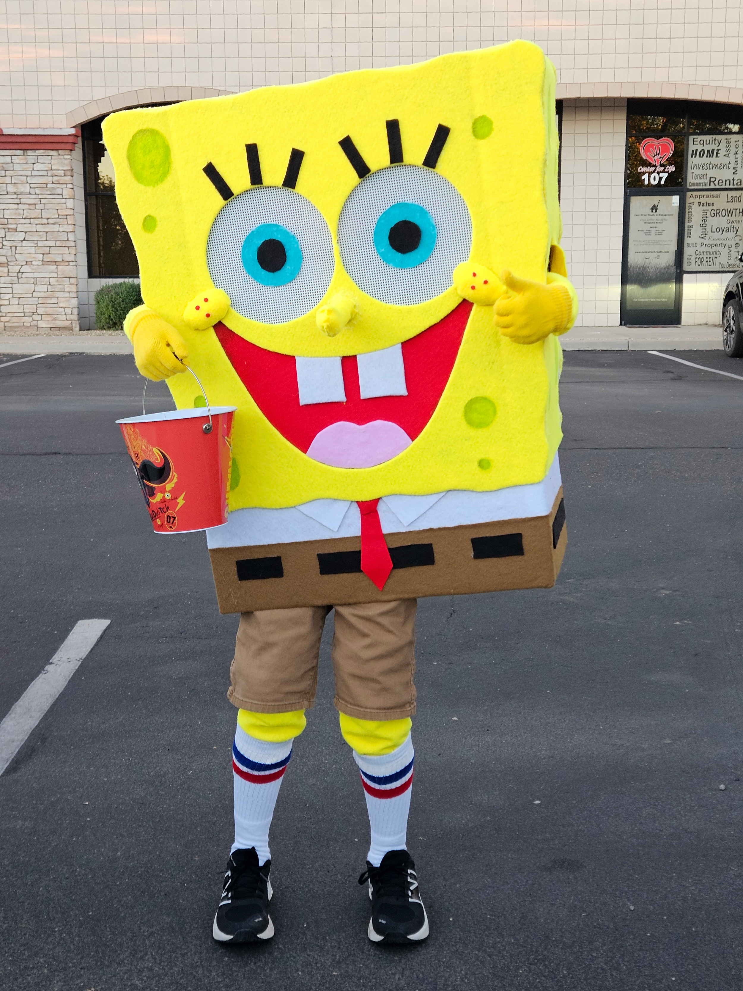 My son posing in parking lot in a home made costume of Sponge Bob Square Pants 