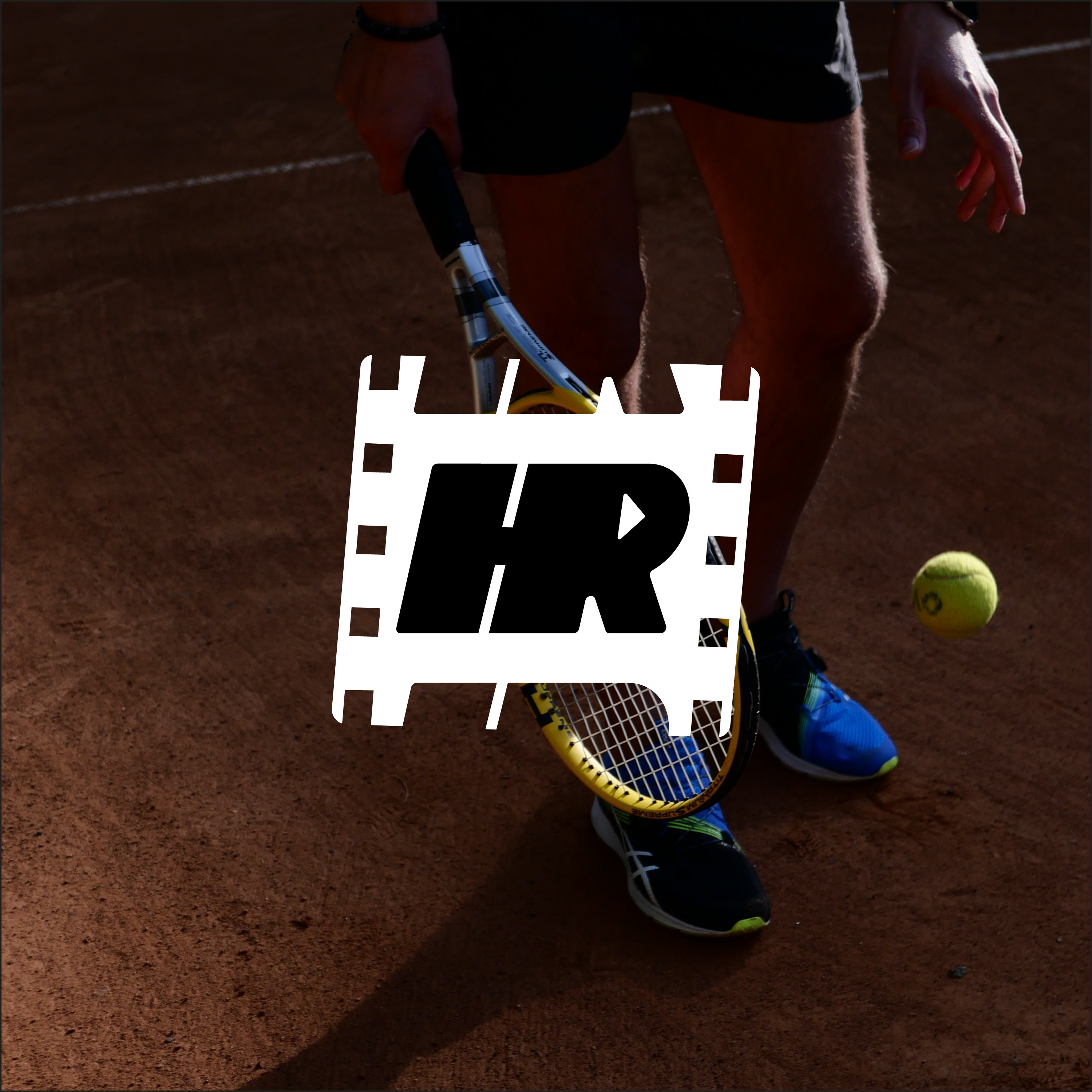 Person wearing blue and black sneakers holding a tennis racket and ready to hit a tennis ball on a clay court.