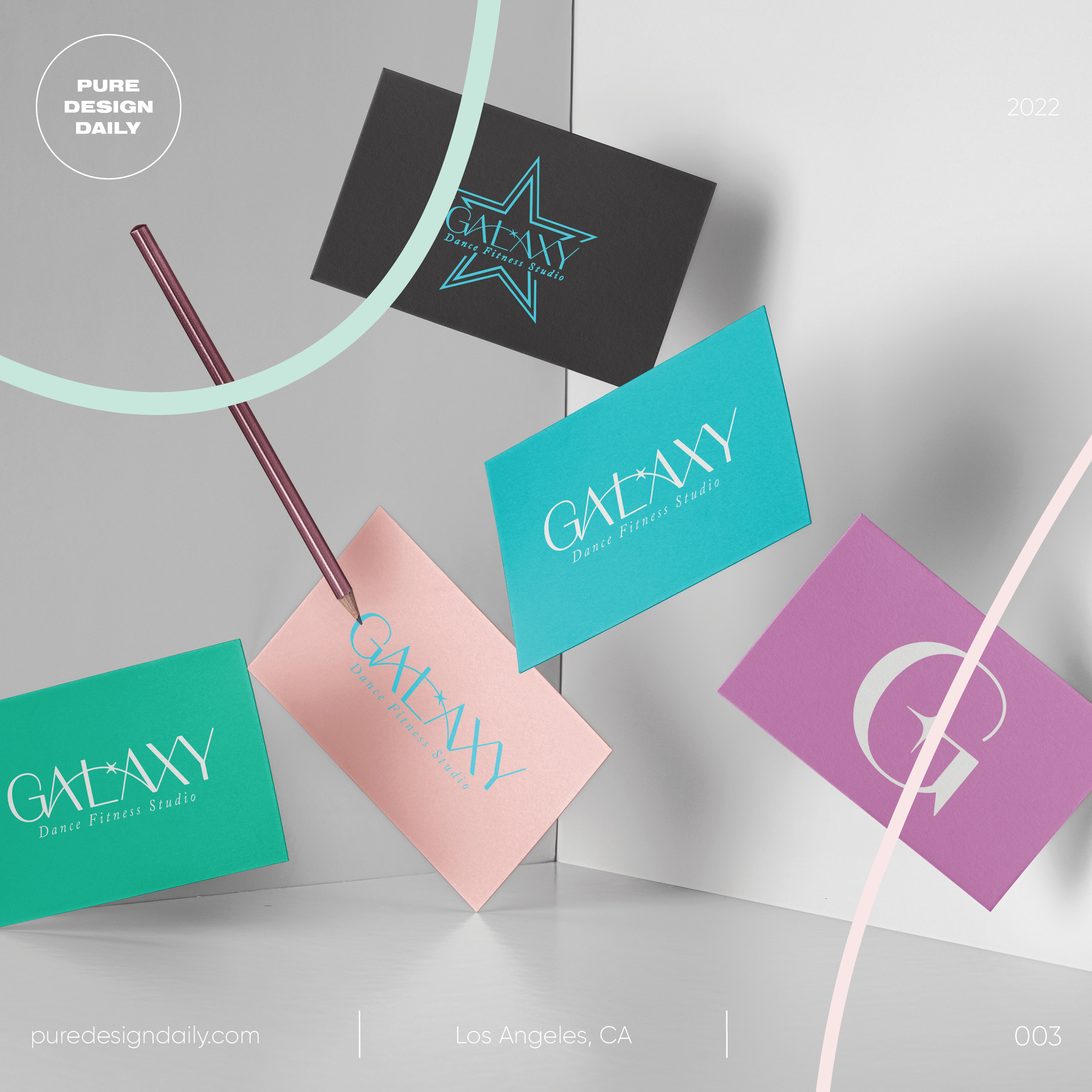 Five colorful Galaxy Dance Fitness Studio business cards arranged on a gray and white surface with a pencil pointing to one card.