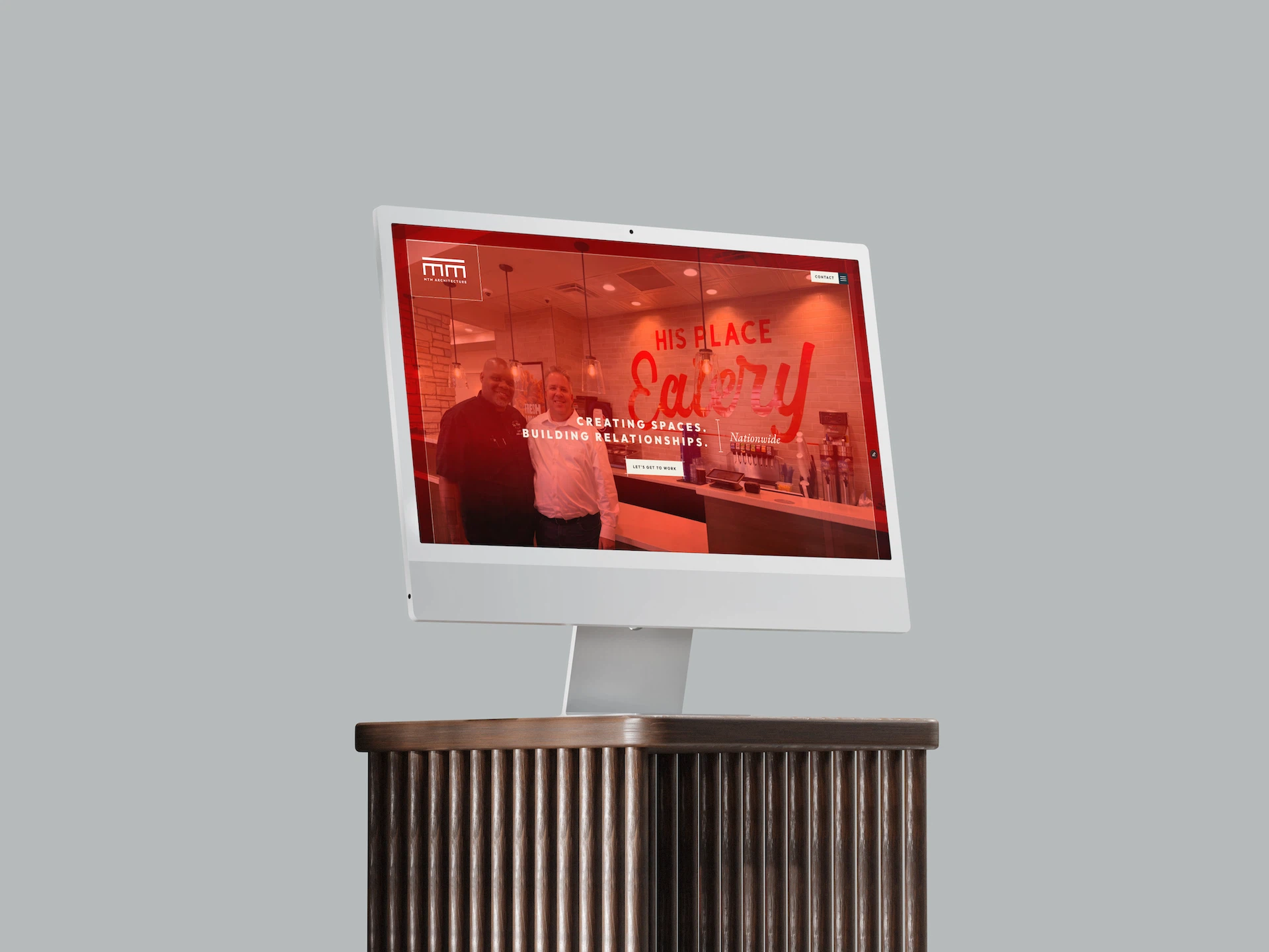 Mann som holder telefon med skjermbilde av MTM Architecture webside