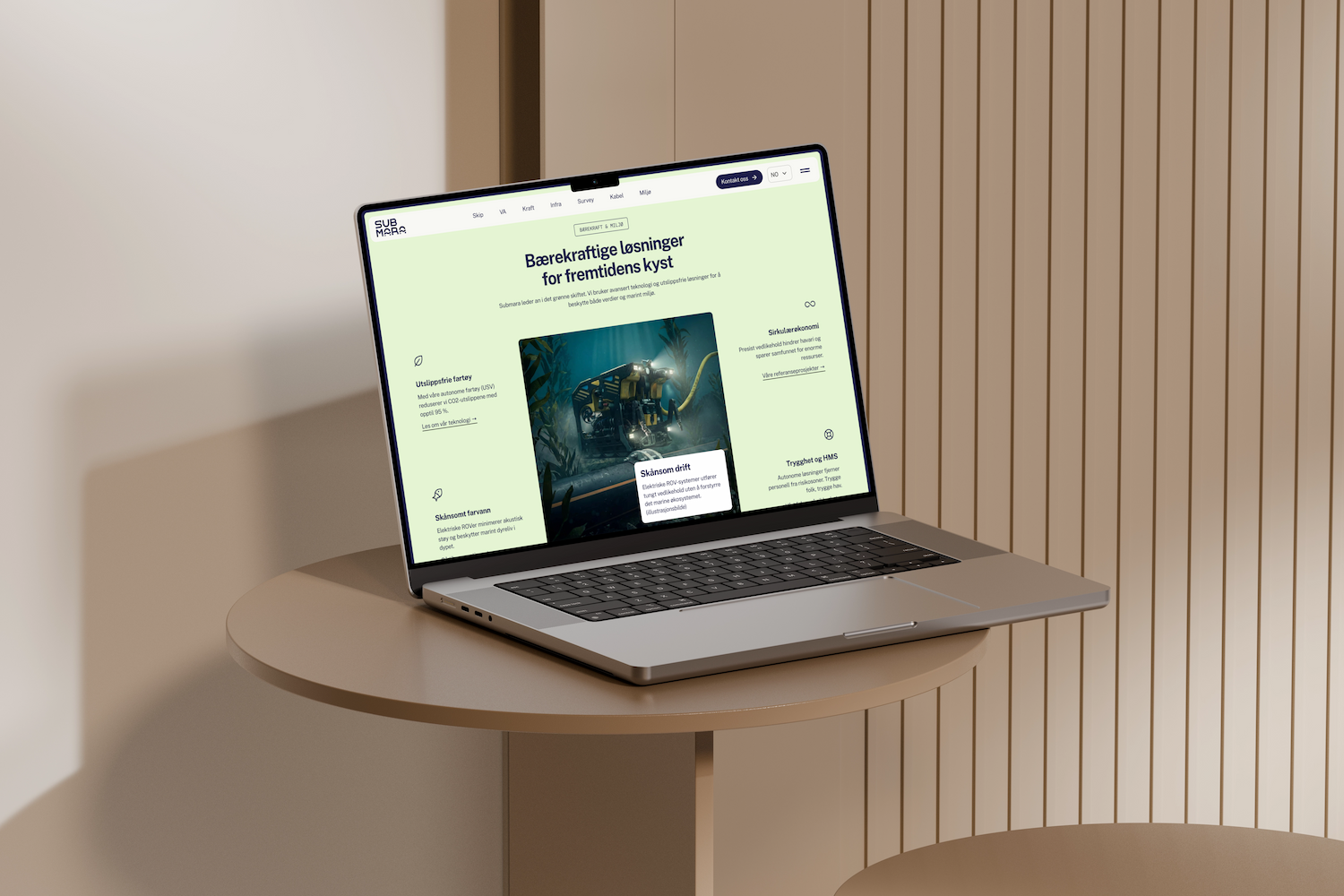 Submara-nettside vist på MacBook Pro på rundt bord