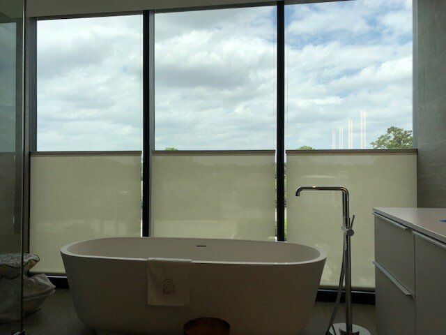 Motorized bottom-up specialty roller shades providing privacy while preserving sky views