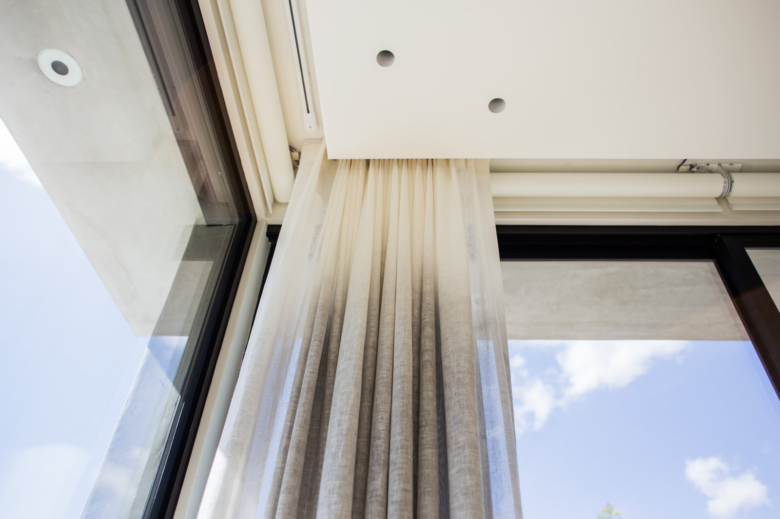 Recessed motorized drapery track integrated into a ceiling pocket