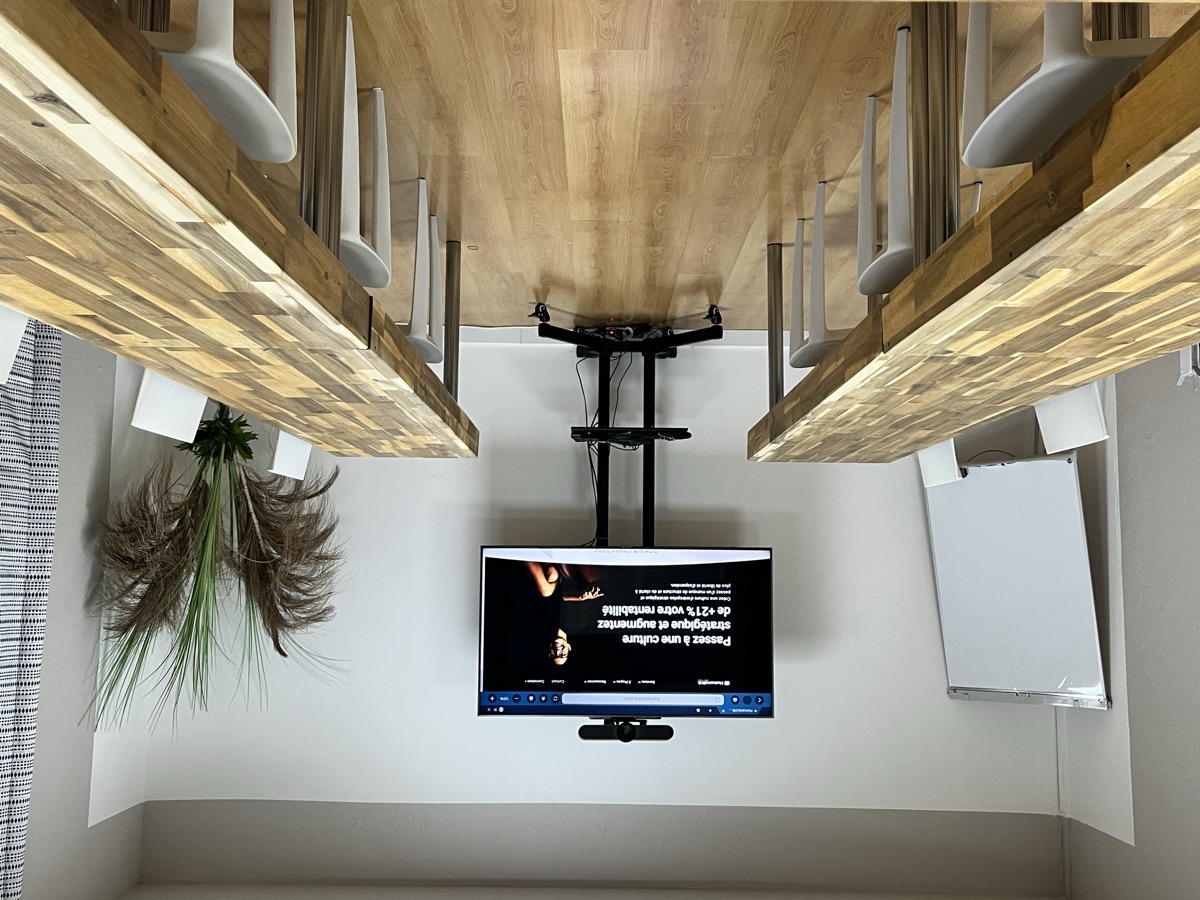 Salle L'Herbier : tables en bois, écran connecté et paperboard