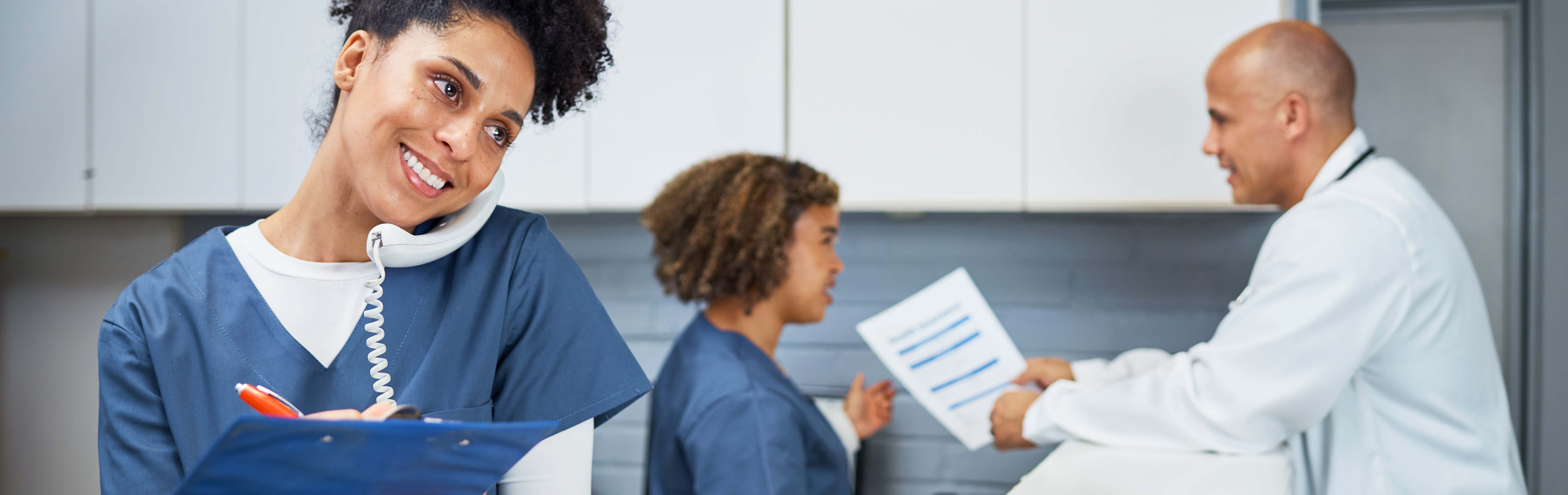 Medical assistant holding a phone and notepad.