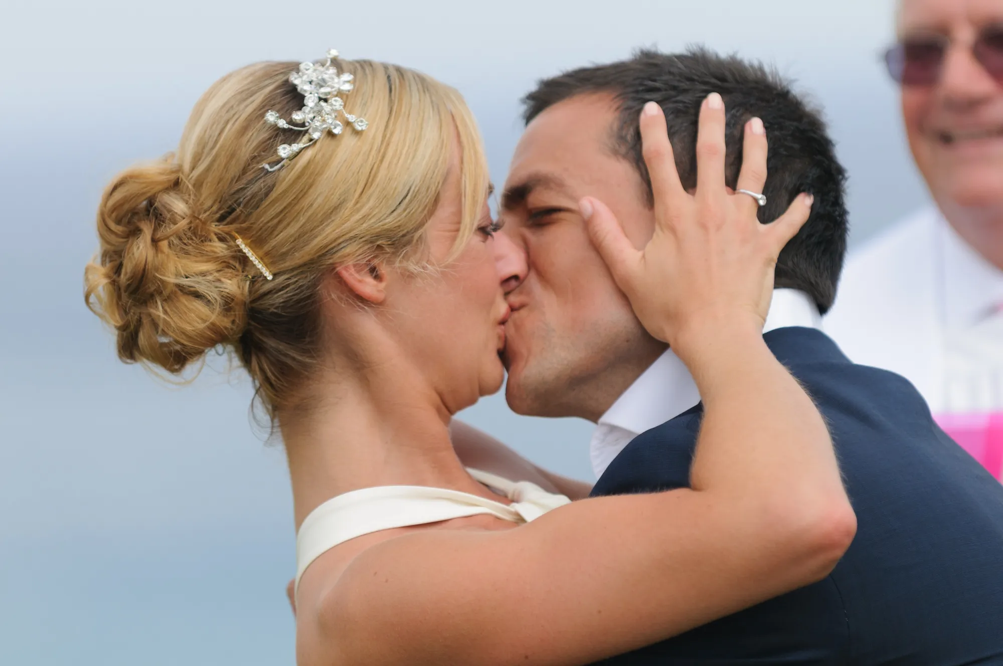 Bride and groom sharing a kiss during a wedding ceremony.