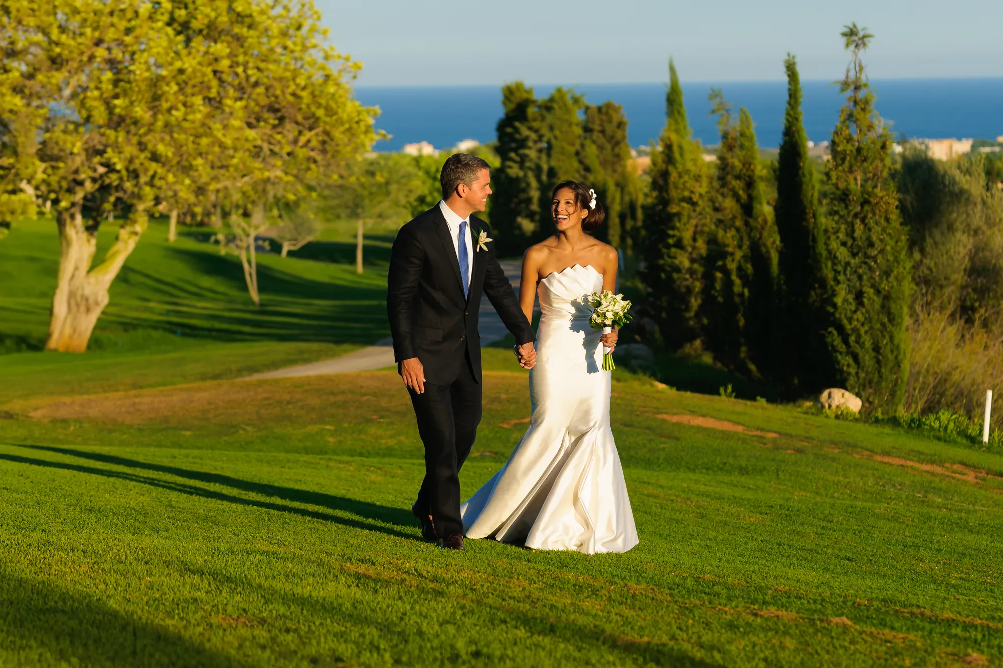 Bride and groom walking in grounds of Vall D'Or Golf Club during golden hour