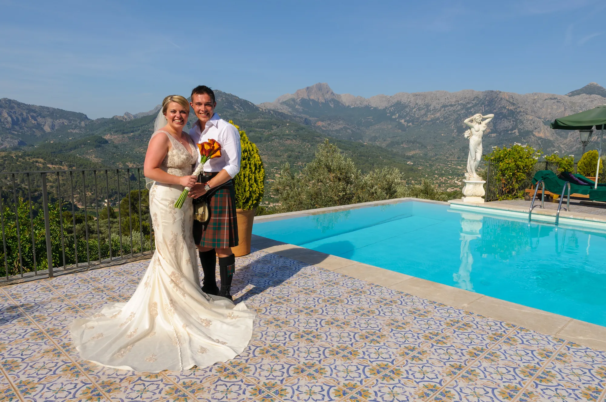 Bride & groom by infinity pool at Ca's Xorc Tramuntana Mountains in distance