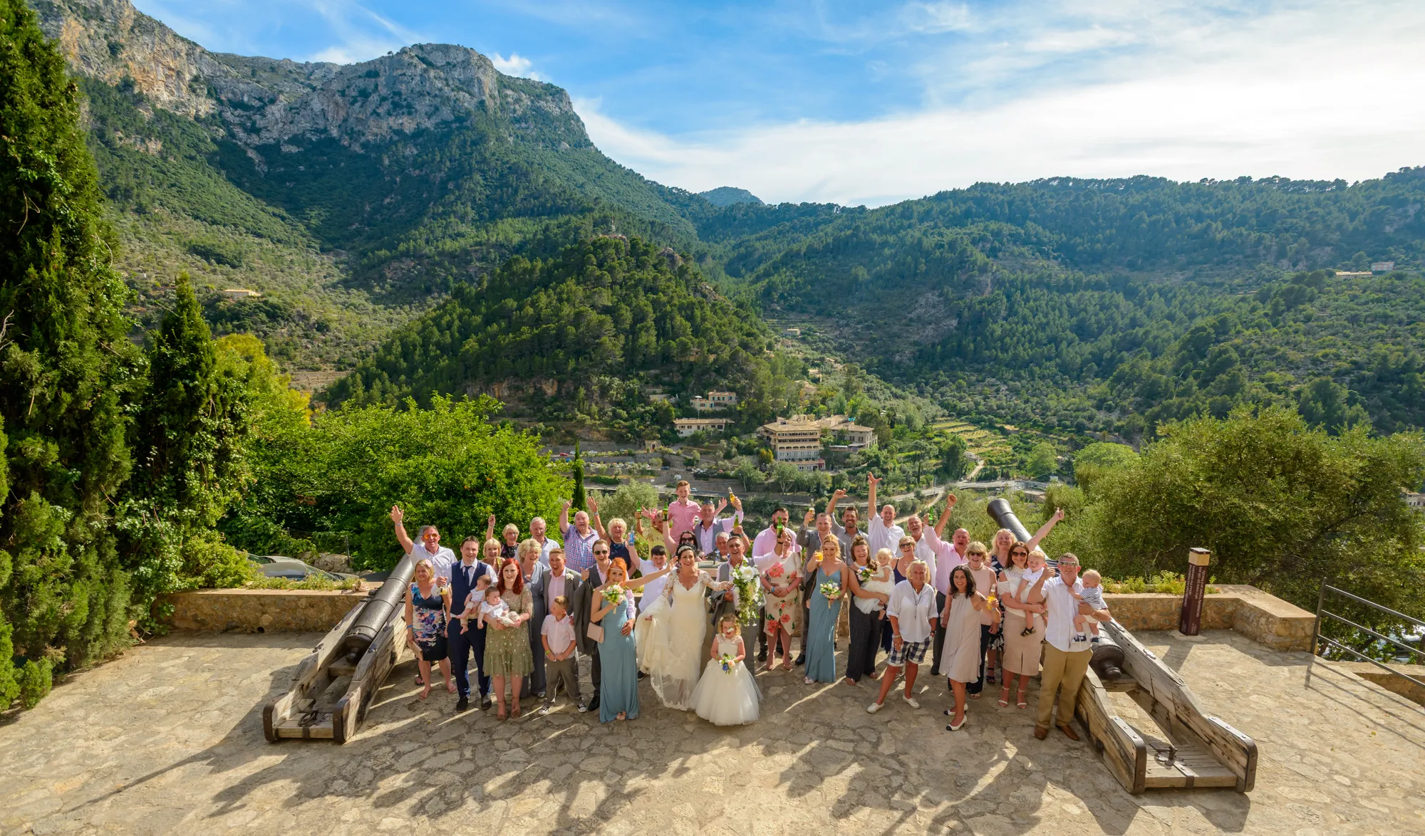 Deia Church wedding group shot with Tramuntana Mountains by Andrew Hazard Photography