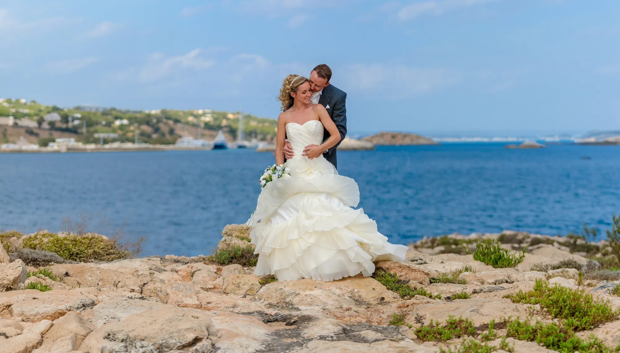 Bride & Groom on rocks overlooking the Mediterranean Sea at Punta Negra by Andrew Hazard Photography