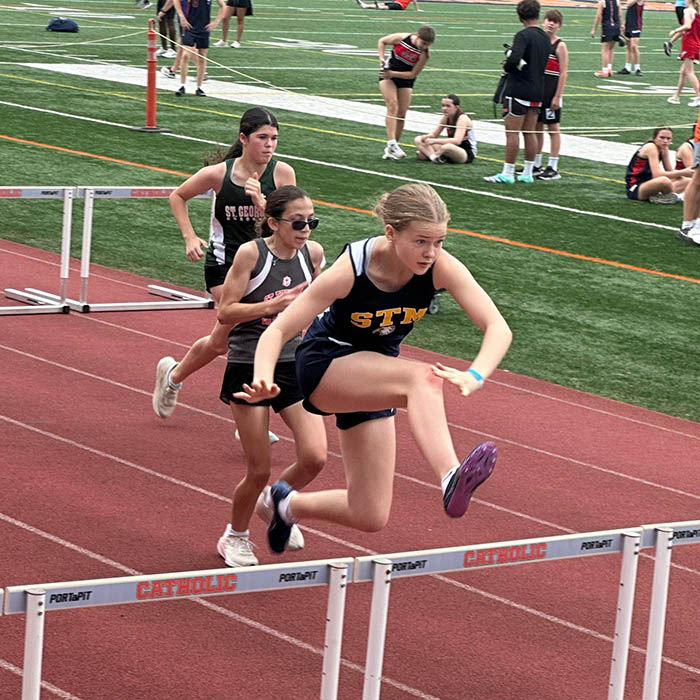 Student jumping over obstacle during track & field