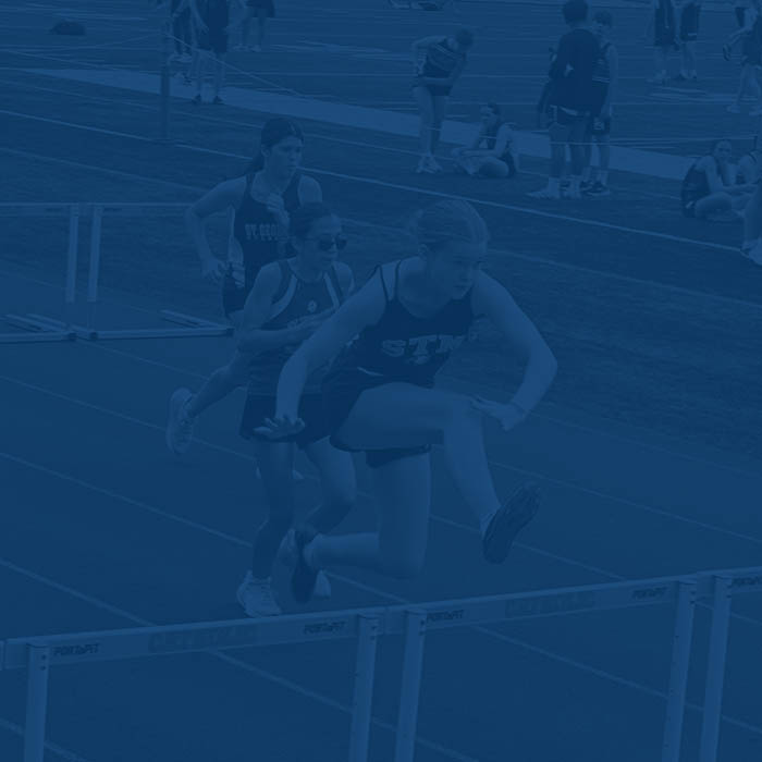 Student jumping over obstacle during track & field