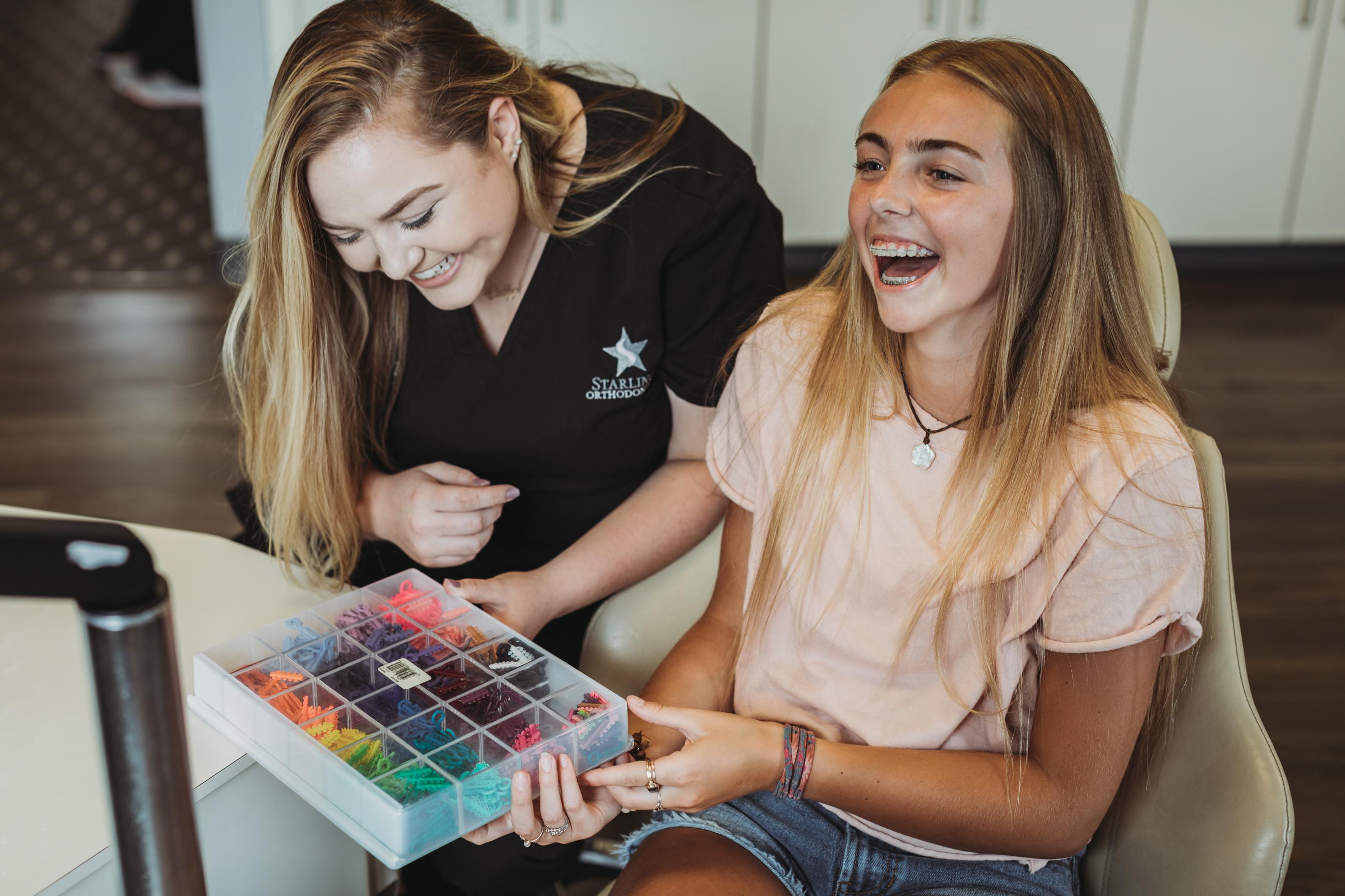 A teenager is sitting in an orthodontic treatment chair, with clear braces with a confident smile. This moment showcases the importance of orthodontic care in achieving a healthy smile, emphasizing the positive experience many children have during their dental visits in Nashville.