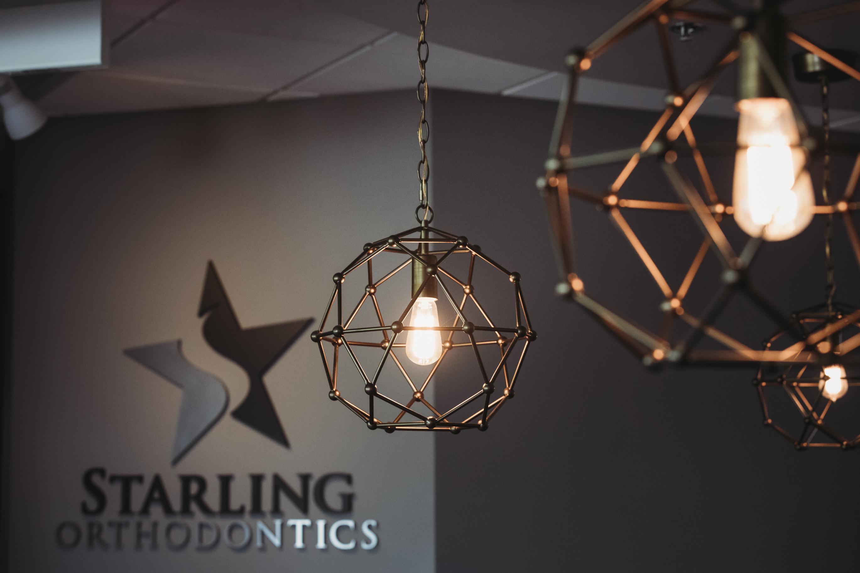 Interior of Starling Orthodontics office in Brentwood, TN featuring modern pendant lighting and branded wall logo
