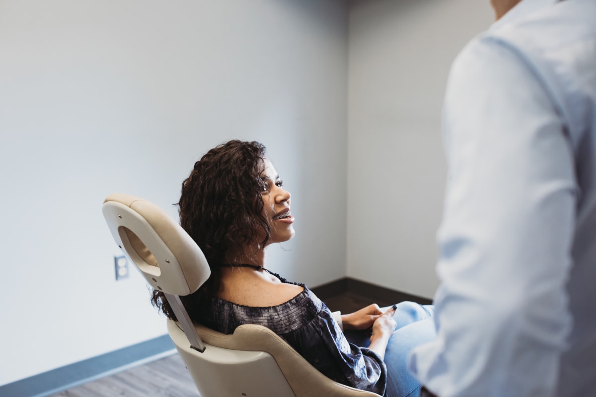 Orthodontist showing a smiling young patient her teeth alignment progress during treatment consultation