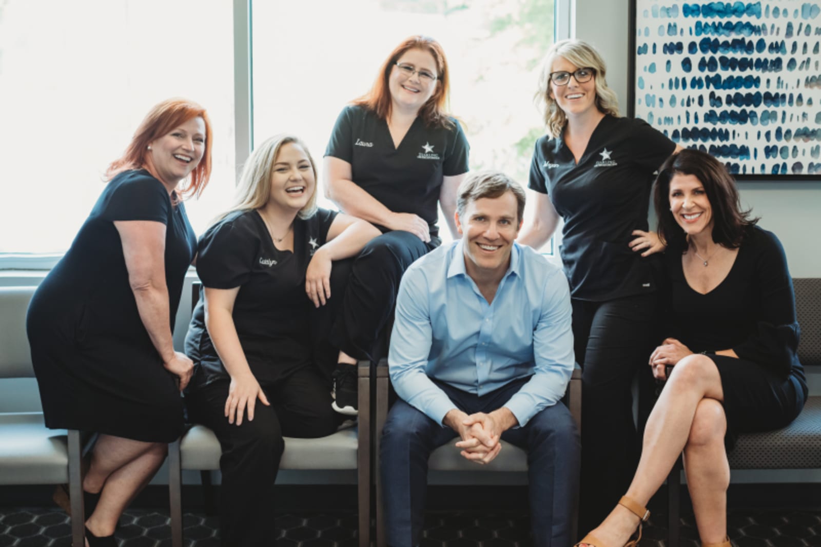 Team photo of orthodontic staff members standing together in the office reception area
