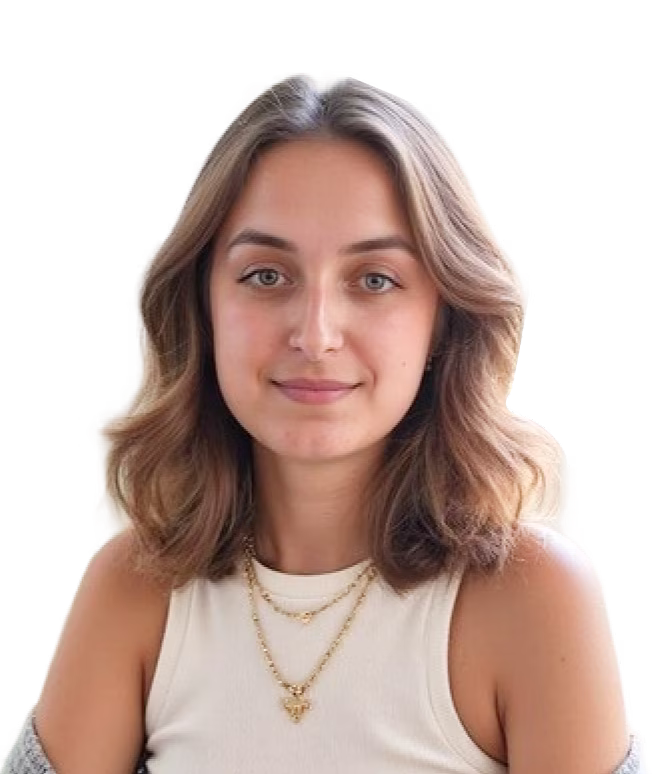 Portrait of a woman with shoulder-length light brown hair, wearing a white top and gold necklaces,