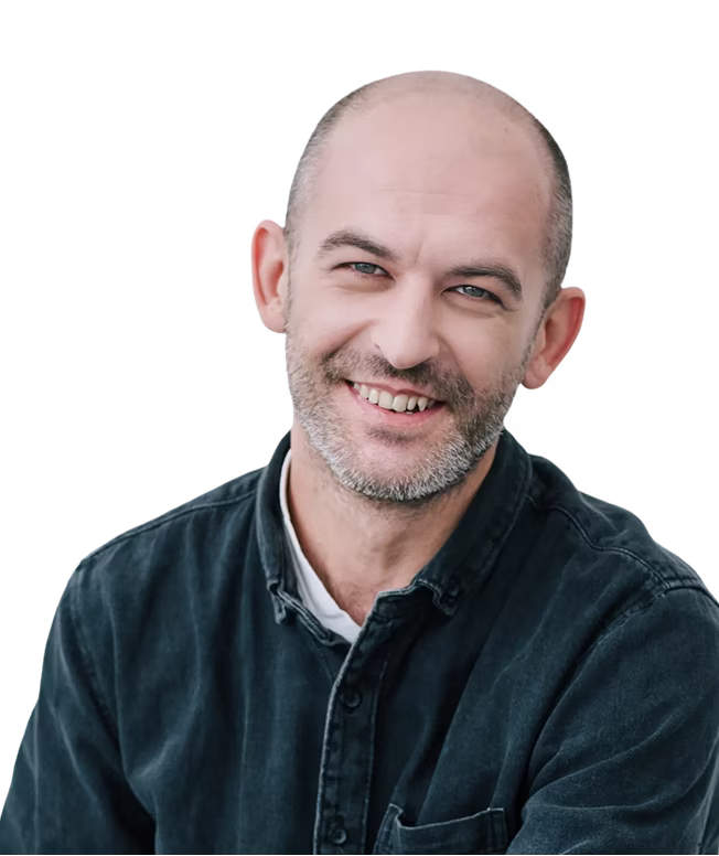 Smiling man with a beard and bald head wearing a dark shirt 