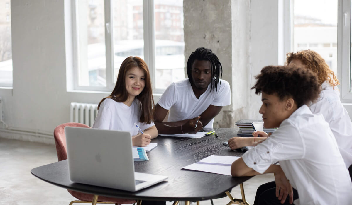 Gruppe Lernender steigert ihre Lernmotivation gemeinsam am Laptop im Online-Lernen