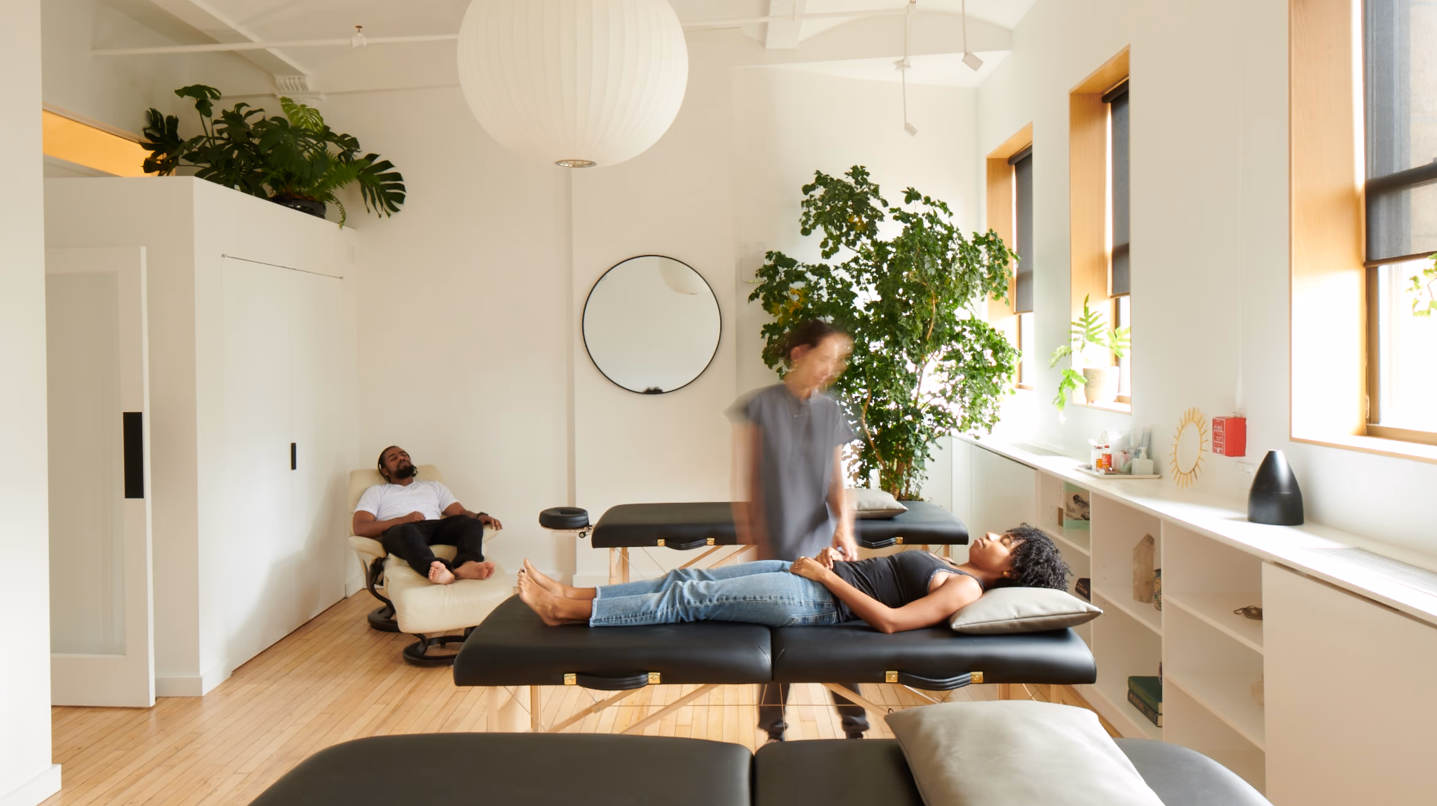 Patients being treated in a recliner and on a table, in the community room at Olo Acupuncture in Chelsea.