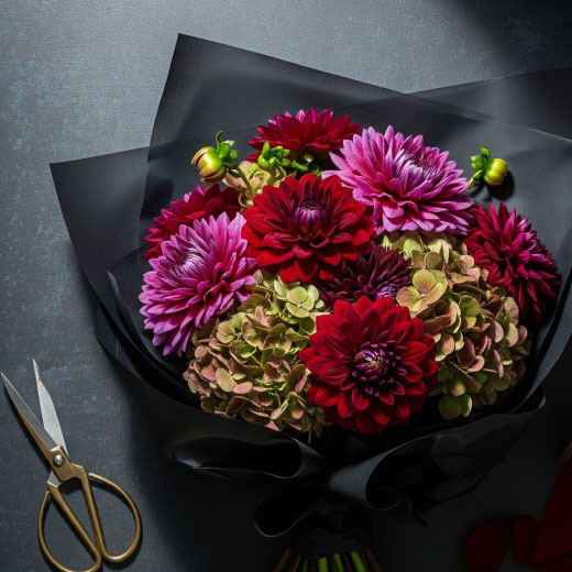 An arrangement of flowers on top of black waxed tissue paper
