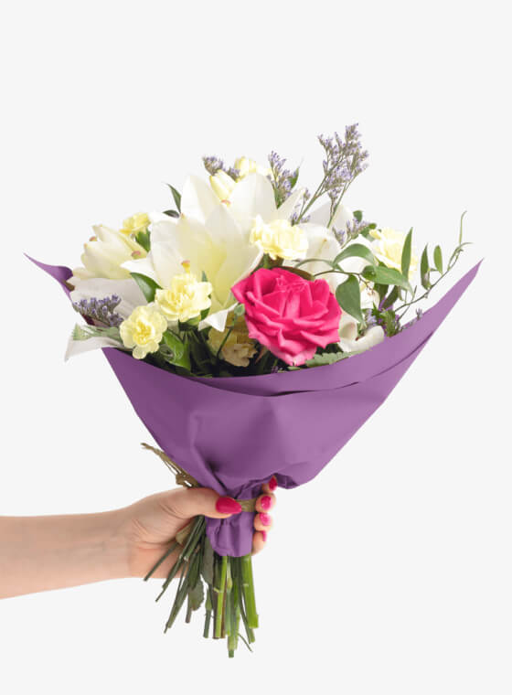 A hand holding bright purple wax floral tissue paper