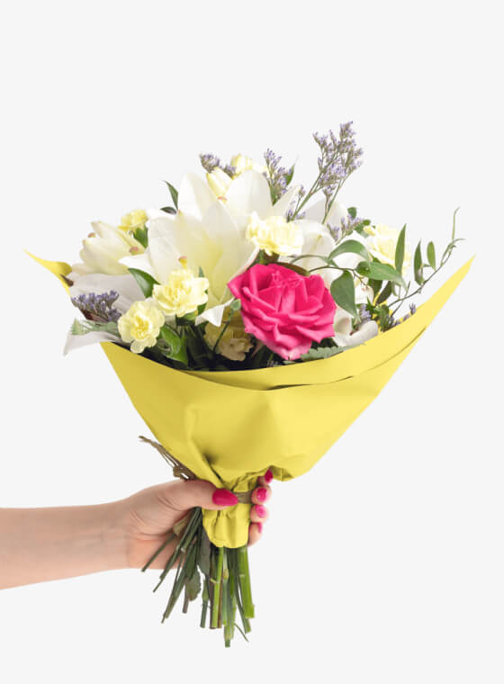 A hand holding bright yellow wax floral tissue paper
